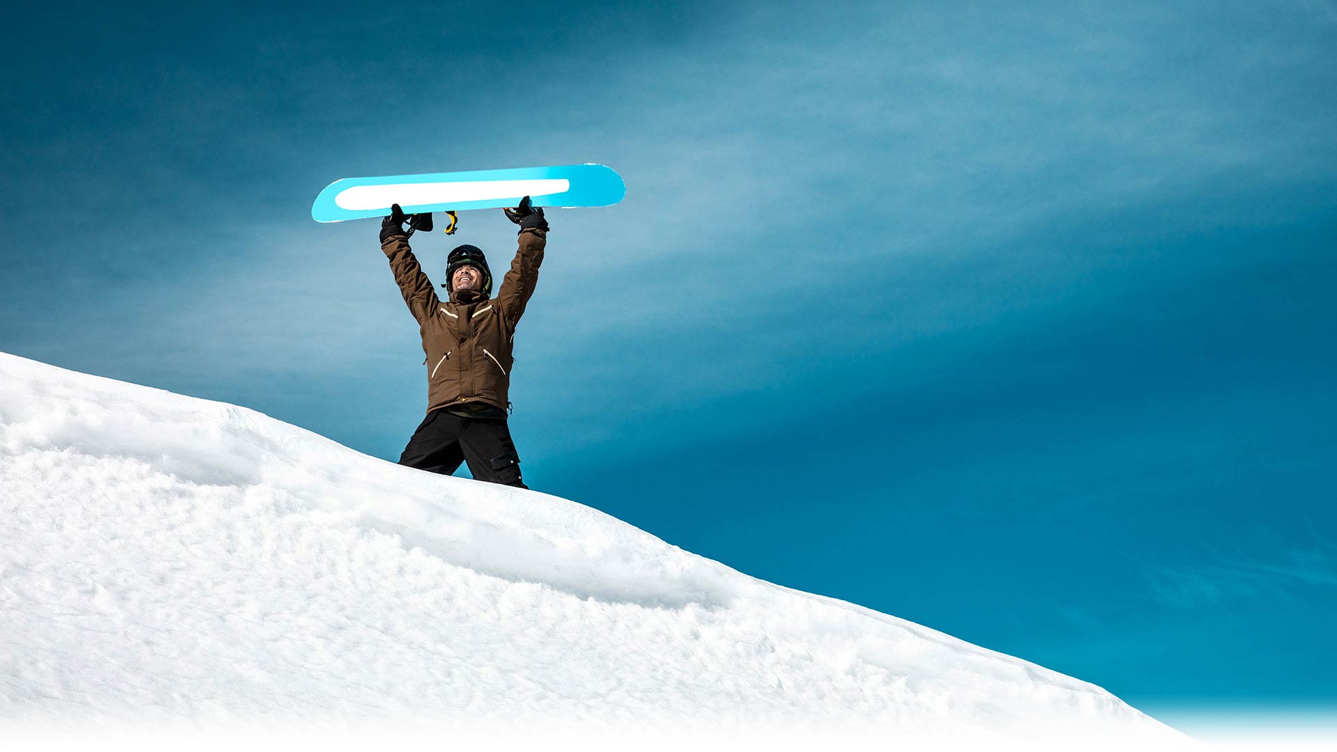 Personne levant les bras avec un snowboard dans la neige